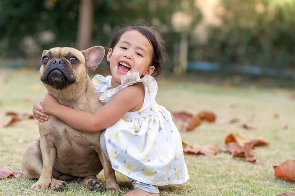 Una Piccola Ragazza Asiatica Che Ride Coccola Suo Bulldog Francese — Foto Stock
