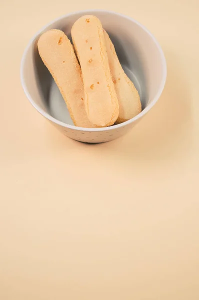 Een Verticaal Shot Van Een Kom Koekjes Een Oranje Oppervlak — Stockfoto