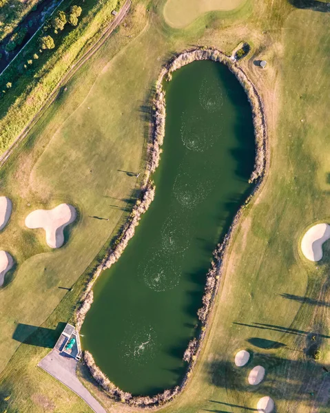 Aerial view of the golf court with a small lake in the field, view of the country sport club in Cruz Quebrada-Dafundo, Lisbon, Portugal.