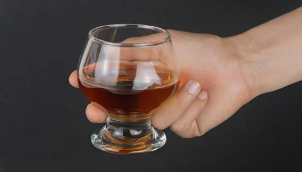 Een Hand Met Een Glas Whisky Een Zwarte Achtergrond Met — Stockfoto