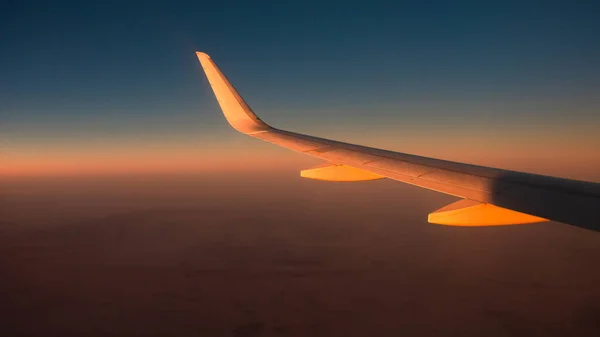 日落时分在35000英尺高空巡航的飞机的翼图 — 图库照片