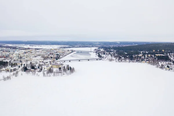 RovaniemiのOunasjoki川の上の建物や鉄道橋と美しい冬の風景 — ストック写真