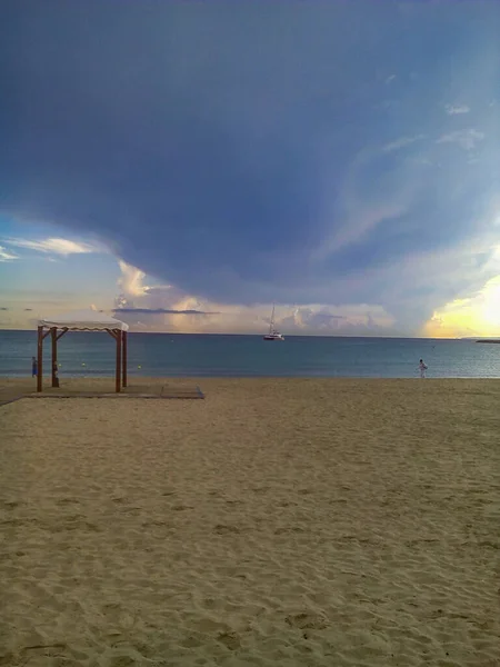Deštníky Písečné Pláži Klidným Mořem Zataženou Oblohou — Stock fotografie