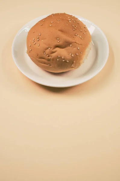 Een Verticaal Shot Broodbroodbroodje Een Plaat Geïsoleerd Een Bruine Achtergrond — Stockfoto