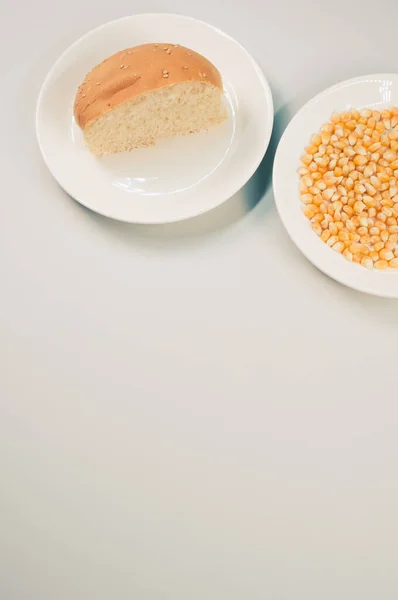 Вертикальный Снимок Полухлебной Булочки Кукурузных Зерен Тарелке Белом Фоне — стоковое фото