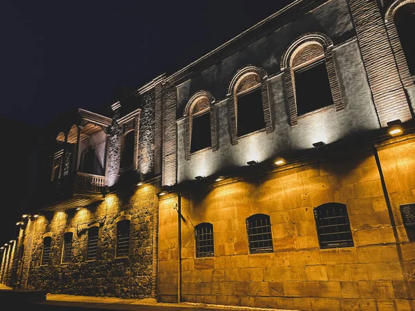 亚美尼亚一座漂亮的石头建筑的低角镜头 夜间灯光闪烁 — 图库照片