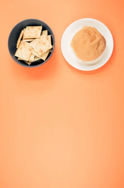 Een Verticaal Shot Van Vierkante Crackers Broodbroodbroodjes Geïsoleerd Een Oranje — Stockfoto