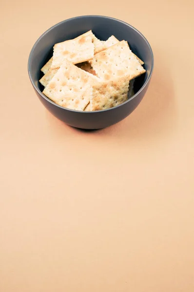 Een Verticaal Schot Van Vierkante Crackers Een Kom Geïsoleerd Bruine — Stockfoto