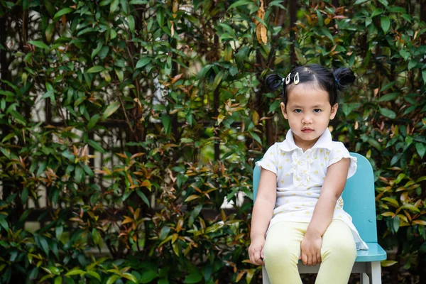 Uma Menina Tailandesa Pequena Bonito Sentado Uma Cadeira Azul Contra — Fotografia de Stock