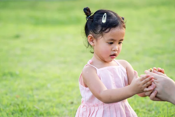 母の手を握っている公園で可愛いタイ人の女の子 — ストック写真
