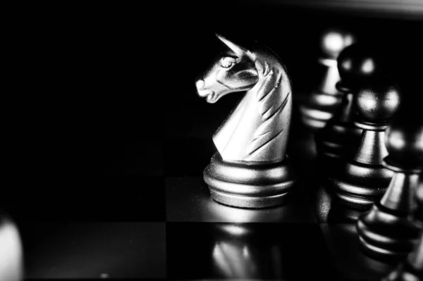 O conjunto de elemento de peças de xadrez dourado, rei, torre de rainha,  bispo, cavalo, pé de peão no tabuleiro de xadrez em fundo escuro.  liderança, trabalho em equipe, parceria, planejamento e conceito de  estratégia de negócios.