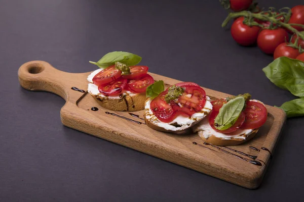 Tasty Bruschetta Cherry Tomatoes Pesto Basil Cheese Wooden Board — Stock Photo, Image