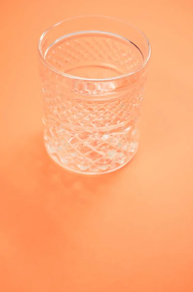 Een Verticaal Shot Van Kristalglas Geïsoleerd Een Oranje Achtergrond — Stockfoto