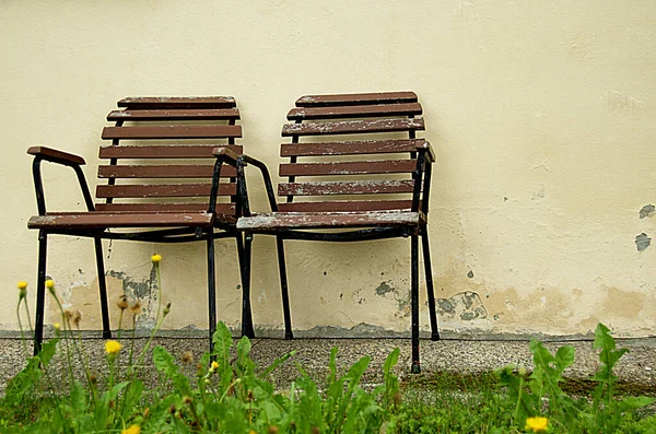 Két Szék Egy Sárga Fal Előtt Pázsit Mellett — Stock Fotó