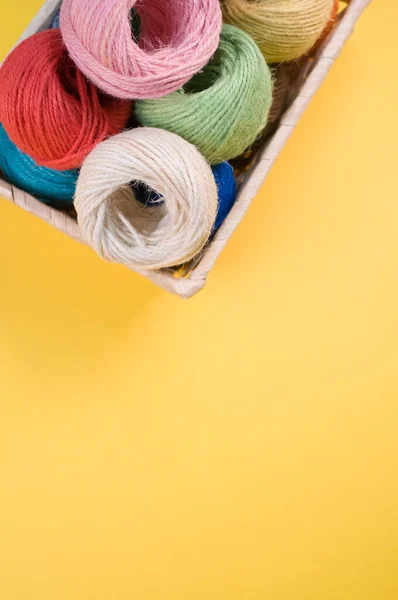 Een Verticaal Shot Van Kleurrijke Garens Een Doos Geïsoleerd Gele — Stockfoto