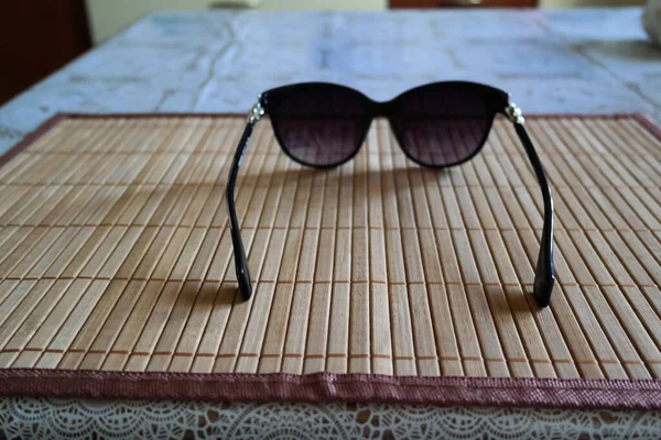 Zbliżenie Ujęcie Czarnych Okularów Przeciwsłonecznych Drewnianej Powierzchni — Zdjęcie stockowe