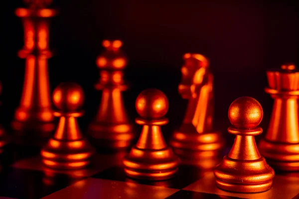 Eine Nahaufnahme Von Schachfiguren Aus Metall Die Mit Knallrotem Licht — Stockfoto