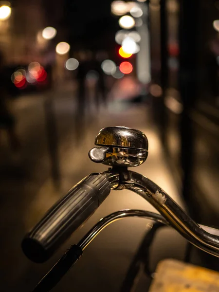 Ett Vertikalt Skott Ett Cykelhandtag Och Klocka Utomhus Natten — Stockfoto