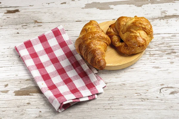 Primer Plano Dos Croissants Tablero Madera Con Una Toalla Cocina —  Fotos de Stock