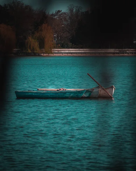 一艘船停泊在一个被黑烟笼罩着的池塘中央的木船 — 图库照片