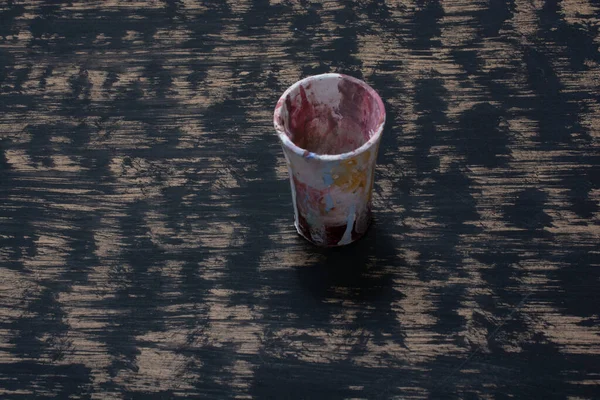 Ein Farbgefärbter Plastikbecher Auf Einem Abstrakten Ölgemälde Hintergrund Eines Schmutzigen — Stockfoto