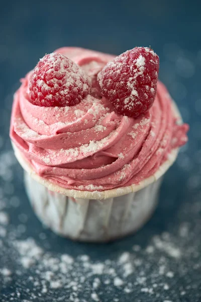 Close Delicioso Cupcake Rosa Com Framboesas Isoladas Fundo Azul — Fotografia de Stock