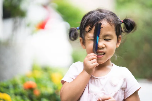 Een Schattig Zuidoost Aziatisch Vrouwelijk Kind Spelen Met Vogel Veer — Stockfoto