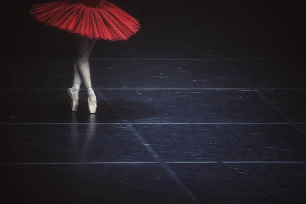 赤いドレスを着て暗いステージで演奏するバレリーナ — ストック写真