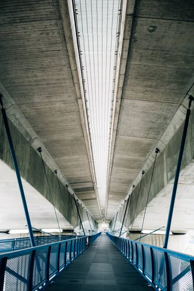 コンクリートの屋根と金属格子と青の手すりを持つ歩道橋の垂直ショット — ストック写真