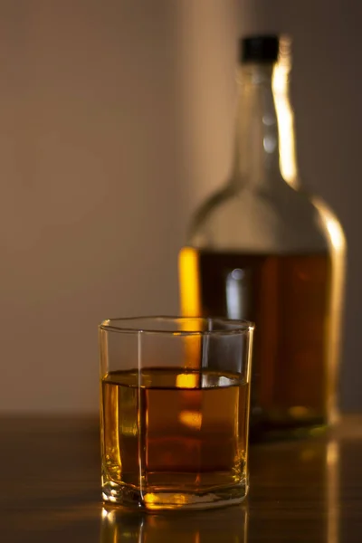 Ένα Μπουκάλι Και Ένα Ποτήρι Κεχριμπαρένιο Ουίσκι Στο Τραπέζι — Φωτογραφία Αρχείου