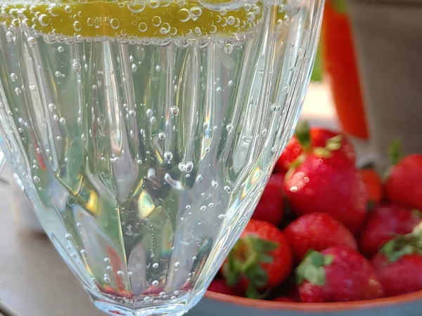 Limón Rodajas Sumergido Una Bebida Cóctel Con Fondo Fresas Borrosas —  Fotos de Stock