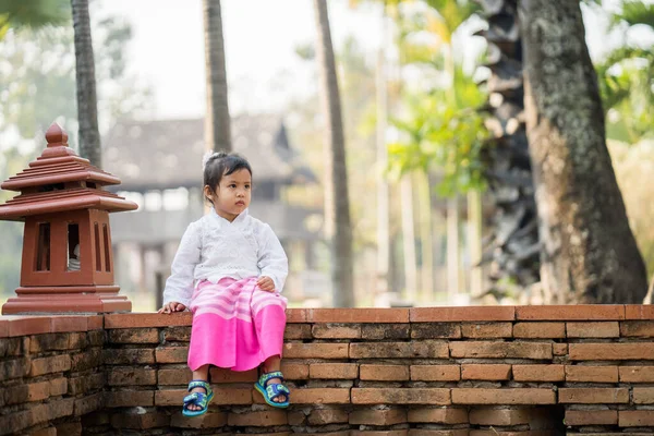 Миленькая Азиатка Традиционном Тайском Платье Сидящая Кирпичном Заборе — стоковое фото