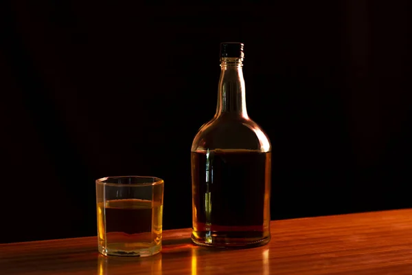 Flaska Och Ett Glas Bärnstensfärgad Whisky Bordet Med Svart Bakgrund — Stockfoto