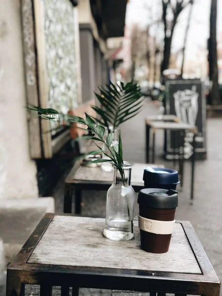Две Кофейные Чашки Вынос Ваза Цветами Столе Открытого Кафе — стоковое фото