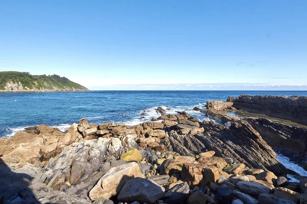 Een Close Van Een Rotsachtig Strand Met Blauw Water Een — Stockfoto