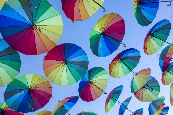 Ein Niedriger Winkel Aus Regenbogenfarbenen Regenschirmen Hängt Über Dem Gehweg — Stockfoto