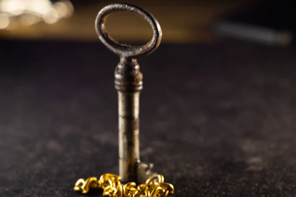 Een Oude Sleutel Met Een Gouden Ketting Een Getextureerd Oppervlak — Stockfoto