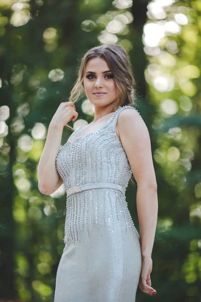 stock image A vertical shot of a young female posing outdoors in a silver dress