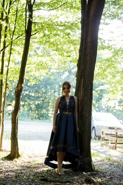 Ένα Λευκό Κορίτσι Στέκεται Κοντά Ένα Δέντρο Ένα Μπλε Φόρεμα — Φωτογραφία Αρχείου