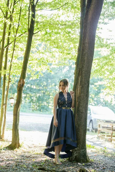 Ένα Ντροπαλό Κορίτσι Στέκεται Κοντά Ένα Δέντρο Ένα Μπλε Φόρεμα — Φωτογραφία Αρχείου