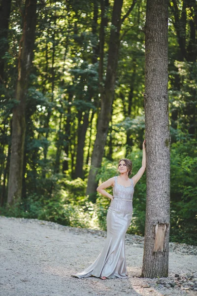 Tiro Vertical Uma Jovem Fêmea Apoiada Uma Árvore Vestido Prata — Fotografia de Stock