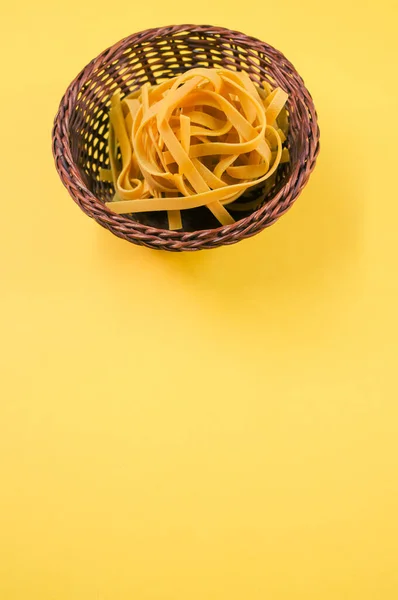 Tiro Vertical Pasta Fettuccine Sin Cocer Sobre Cuenco Mimbre Aislado — Foto de Stock