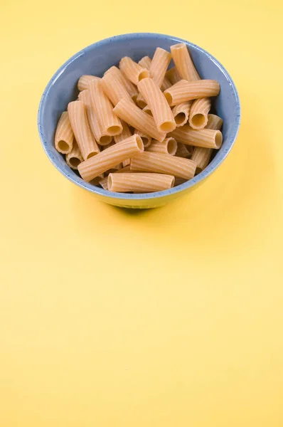 Vertical Shot Uncooked Rigatoni Pasta Bowl Isolated Yellow Background — Stock Photo, Image