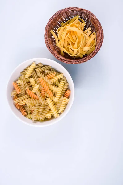 Vertikální Záběr Tříbarevných Rotini Fettuccinových Těstovin Misce Izolované Bílém Pozadí — Stock fotografie