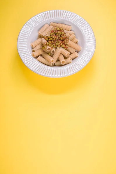 Tiro Vertical Macarrão Rigatoni Com Ervilhas Verdes Uma Placa Isolada — Fotografia de Stock