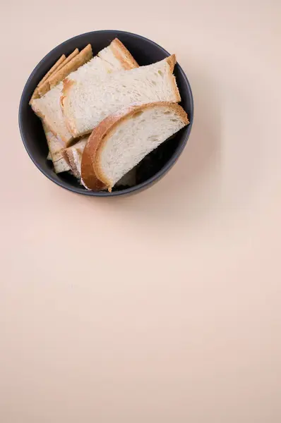 Kahverengi Arka Planda Izole Edilmiş Bir Kase Üzerinde Dikey Ekmek — Stok fotoğraf