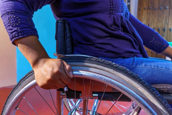 一名坐在轮椅上 背景五彩斑斓的西班牙裔中年残疾妇女 — 图库照片