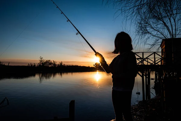 Una Silueta Una Niña Pescando Desde Una Orilla Del Lago — Foto de Stock