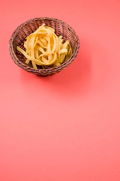 Ein Vertikaler Schuss Ungekochte Fettuccine Pasta Auf Einer Weidenschüssel Isoliert — Stockfoto
