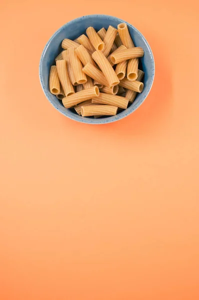 Vertical Shot Uncooked Rigatoni Pasta Bowl Isolated Orange Background — Stock Photo, Image